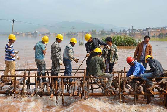 强暴雨导致云南省陆良县板桥镇大坝冲水库决堤，当地纪检监察干部与党员群众一起搭建拦截坝，将人民群众生命财产损失降到最低。（云南陆良纪委  王勇  15887976780）